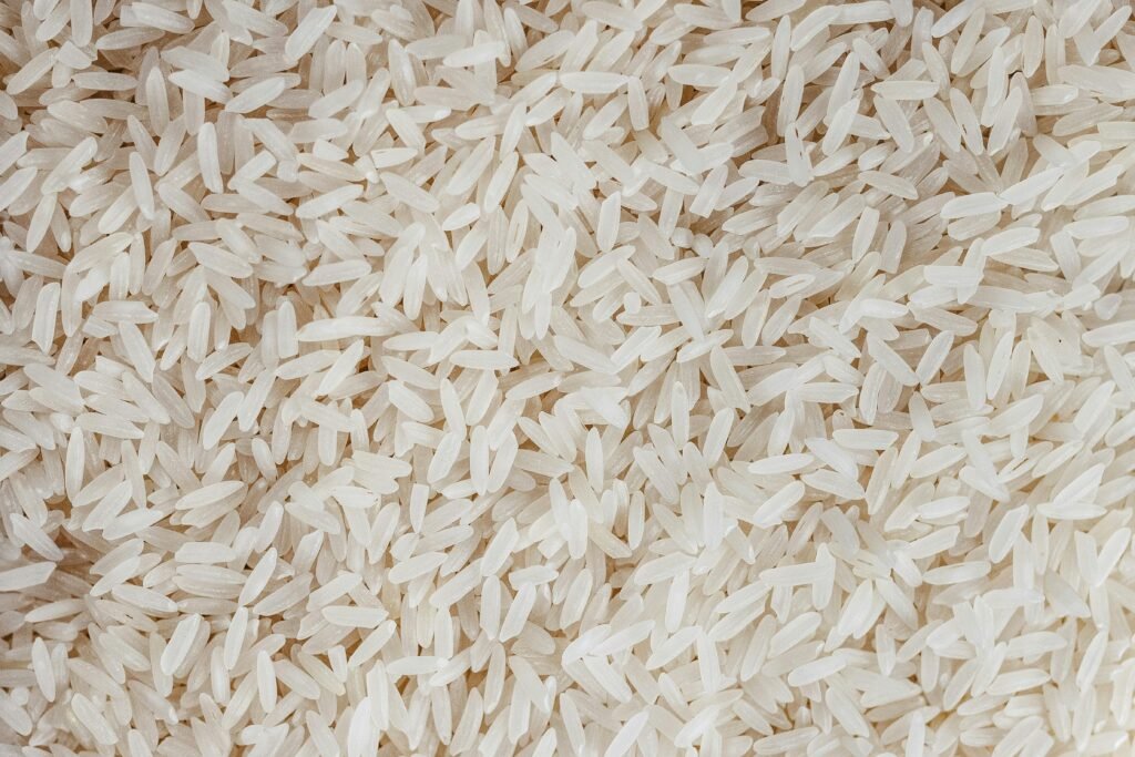 Detailed texture of uncooked white rice grains, perfect for food-related content.