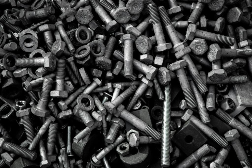 Detailed image of assorted industrial bolts and screws for recycling or mechanics.